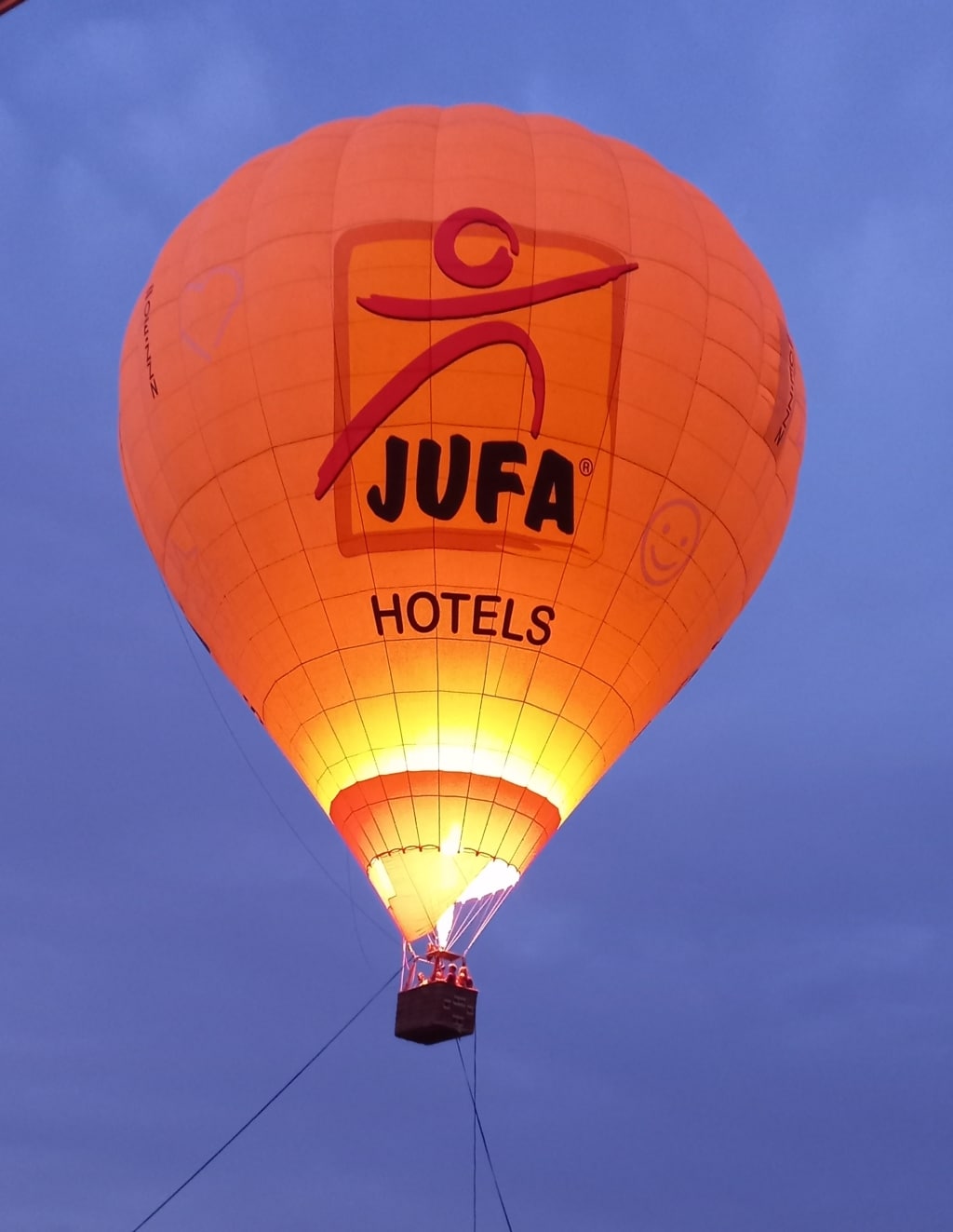 Ein an der Erde festgebundener Heißluftballon, der einige Meter in die Höhe steigt