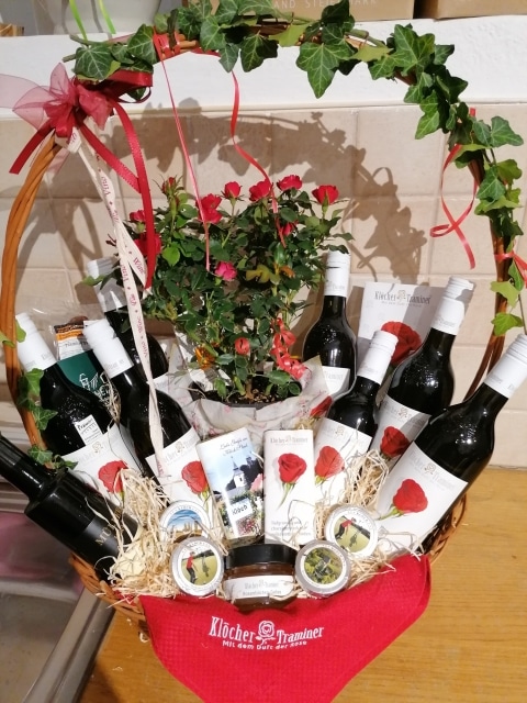Ein Geschenkskorb gefüllt mit Weinflaschen und Produkten rund um den Klöcher Traminer