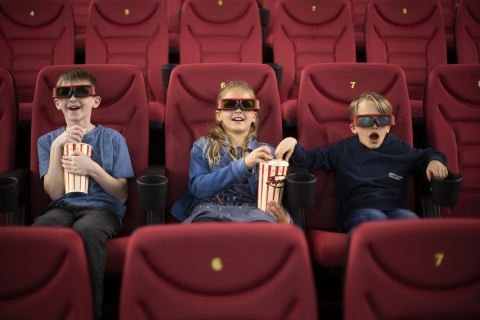 Drei Kinder in Kinosesseln