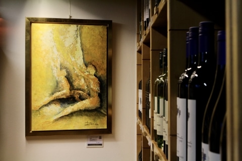 Ein Bild an der Wand und Weinflaschen in einem Regal