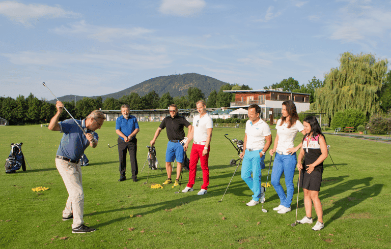 Eine Gruppe von Personen beim Golfunterricht