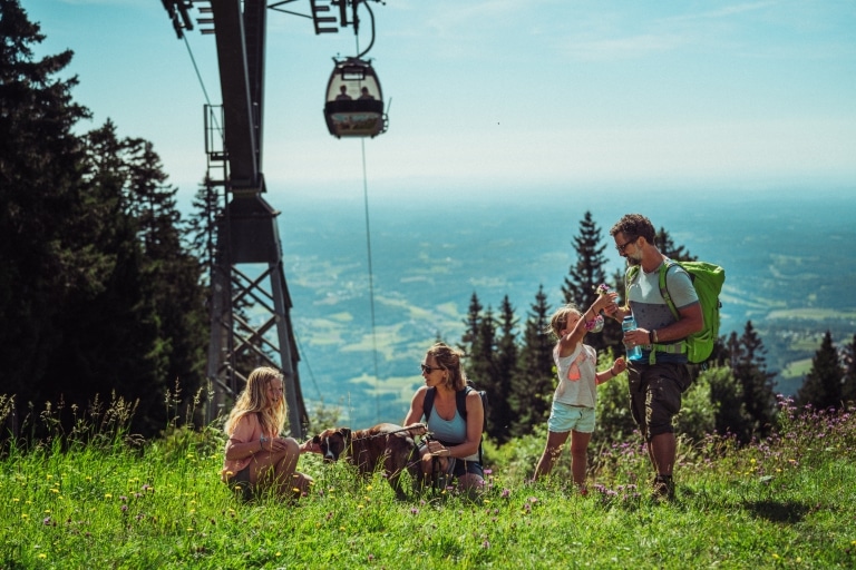 Familie in grüner Wiese mit Blick auf das Grazer Umland