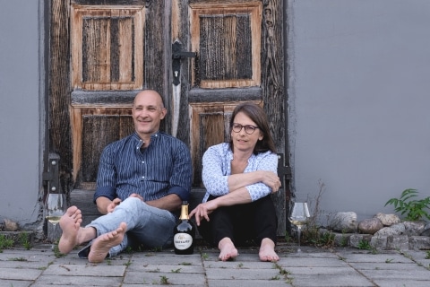Familie Harkamp vor einer Holztüre auf dem Boden sitzend mit einer Flasche Sekt