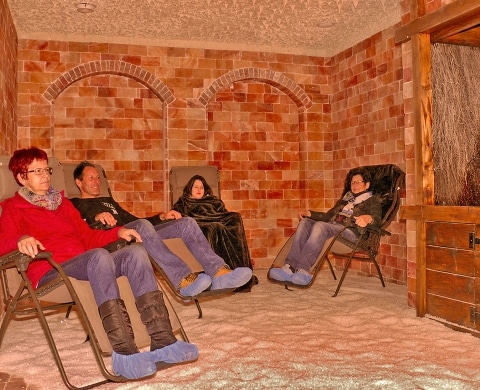 Vier Personen bei einer entspannenden Sitzung in der Salzgrotte