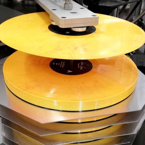 Schallplatten werden von einer Maschine gestapelt