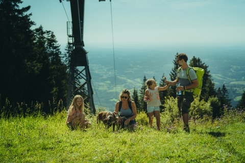 Familie macht Wanderpause auf dem Weg zum Berg