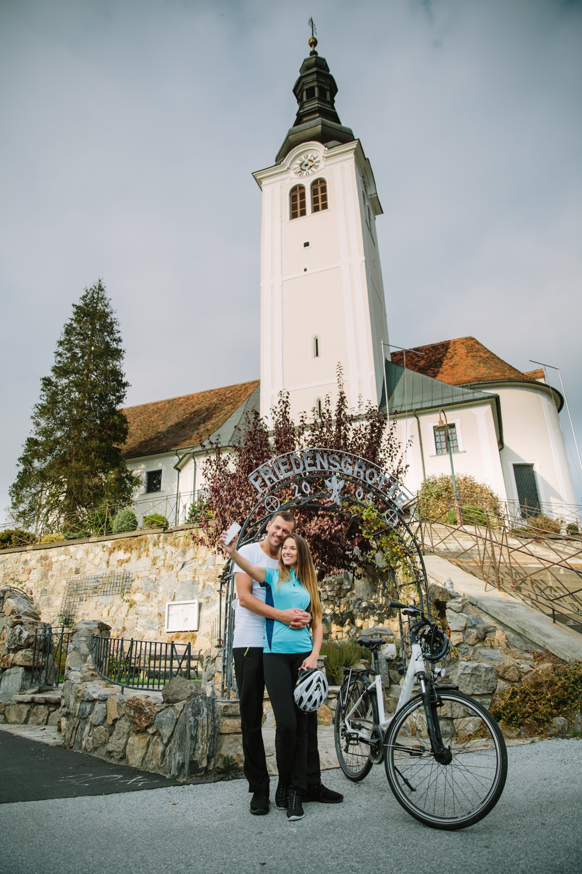 Eine weiße Kirche, und ein Paar mit Fahrrad davor