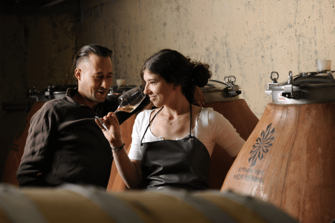Zwei Personen die eine Weinprobe im Weinkeller nehmen