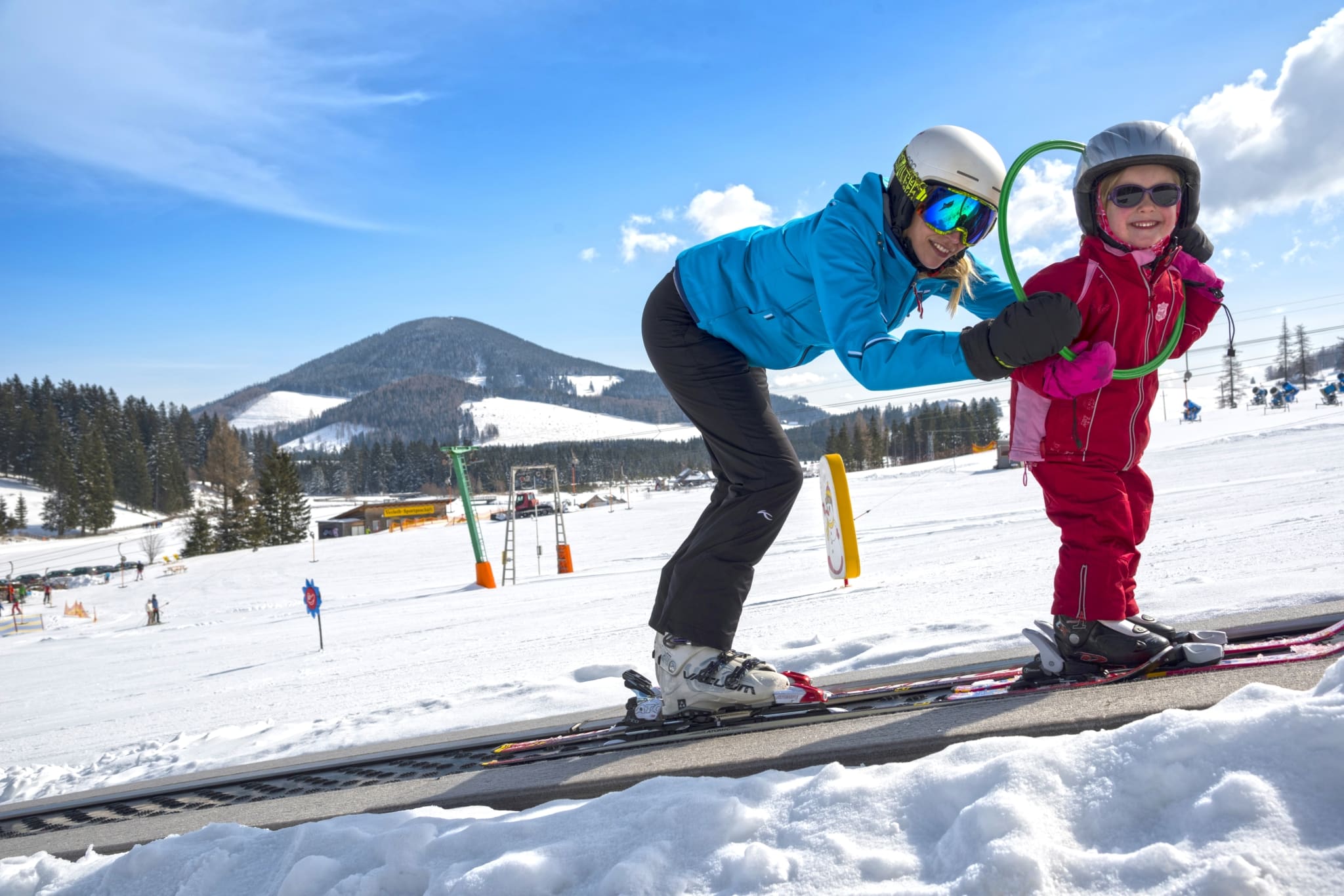 Eine Frau und ein Kind auf Skiern auf der weißen Skipiste