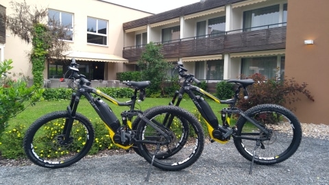 Zwei schwarze E-Bikes stehen vor dem Hotel