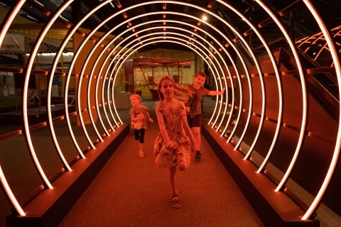 Kinder die durch einen Lichterbogen laufen