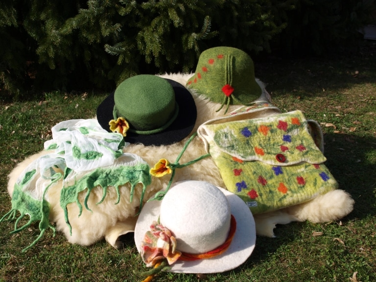 Gefilzte Kleidungsstücke bestehend aus Schal, Hüten und einer Tasche