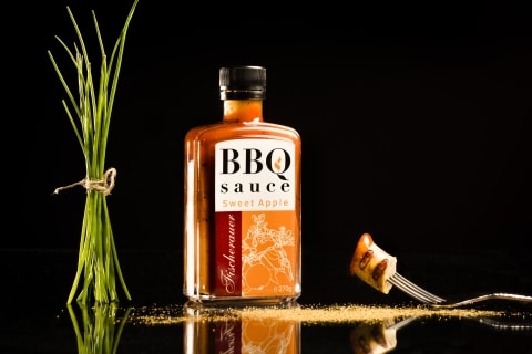Eine Flasche mit BBQ Sauce vor schwarzem Hintergrund