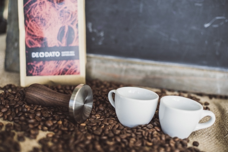 Zwei Espressotassen, die in Kaffeebohnen stehen