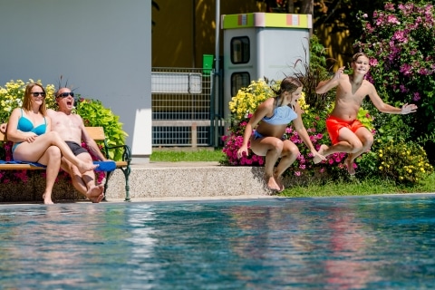 Kinder die in das Becken im Freibad Bad Waltersdorf springen
