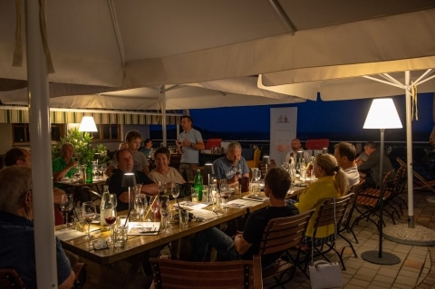Eine Gruppe von Personen am Abend bei einer Weinverkostung
