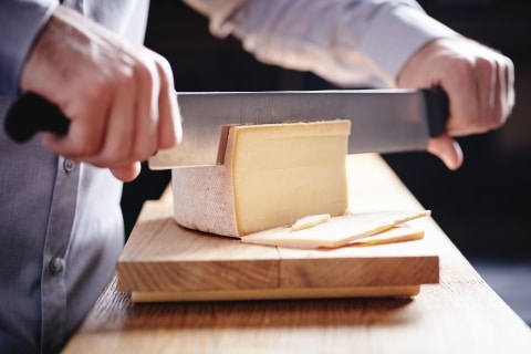 Käse wird heruntergeschnitten