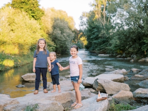 Drei kleine Mädchen in Sommerkleidung im Fluss