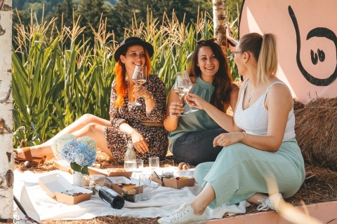 Drei Frauen die auf Strohballen ein Picknick machen