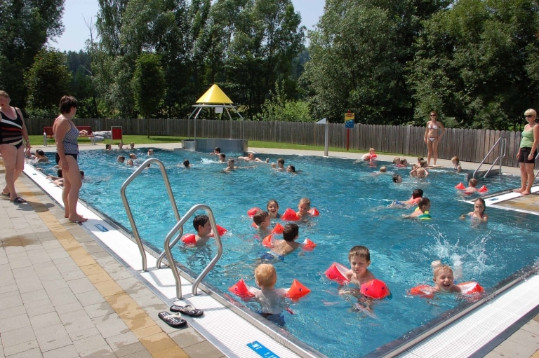 Kinder schwimmen im Edelstahlbecken im Freibad