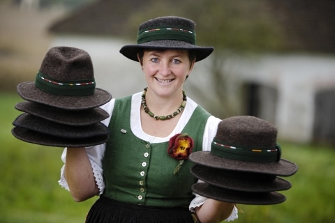 Eine Frau mit gefilzten Hüten auf den HÄnden