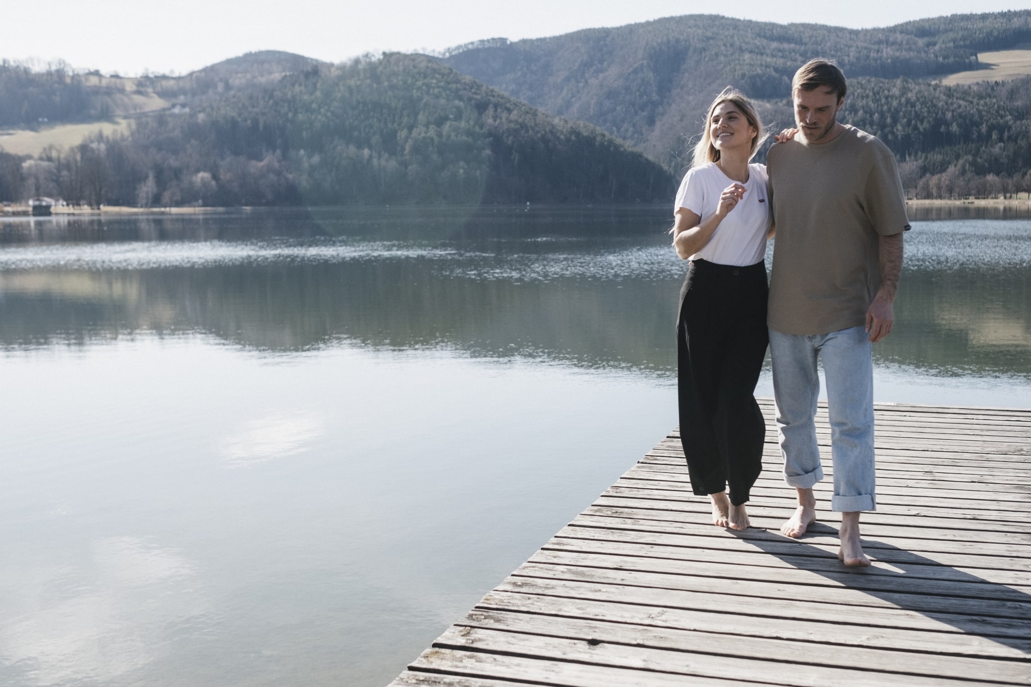 Ein Mann und eine Frau auf einem Steg vor einem See