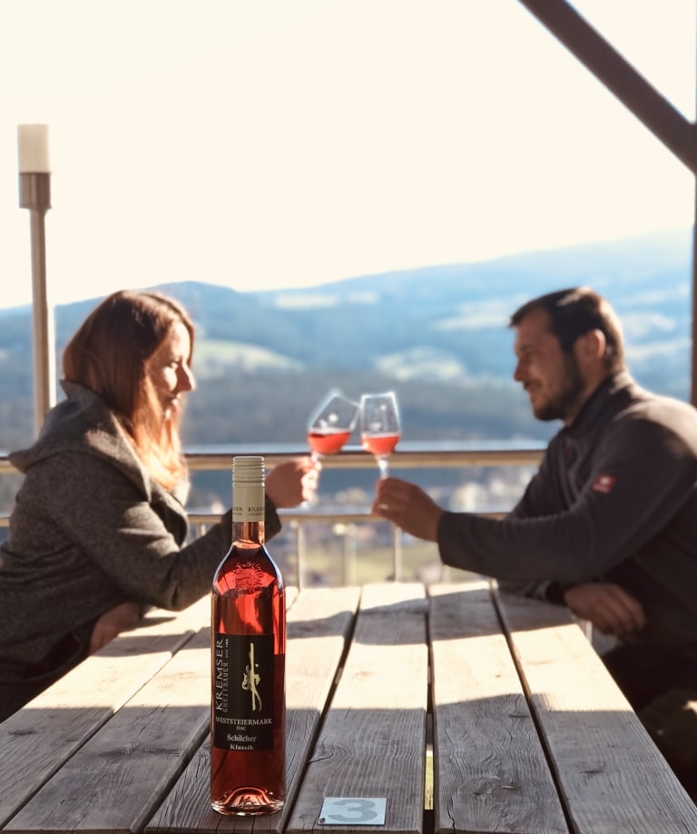 Ein Paar auf einer Terrasse mit Weingläsern in der Hand