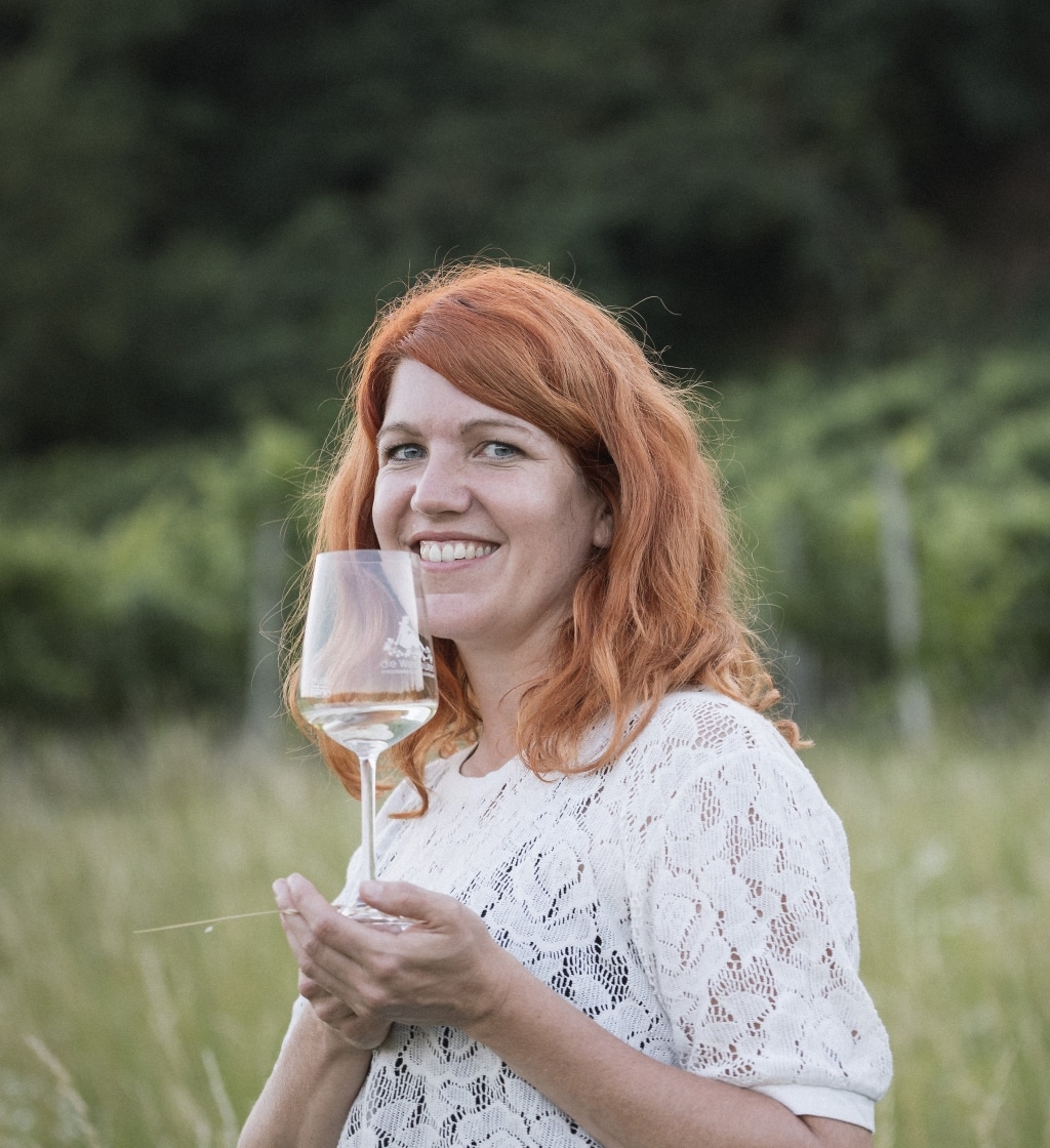 Sigrid Sorger die ein Glas Wein in der Hand hält
