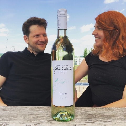 Frau und Herr Sorger hinter einer Flasche Wein
