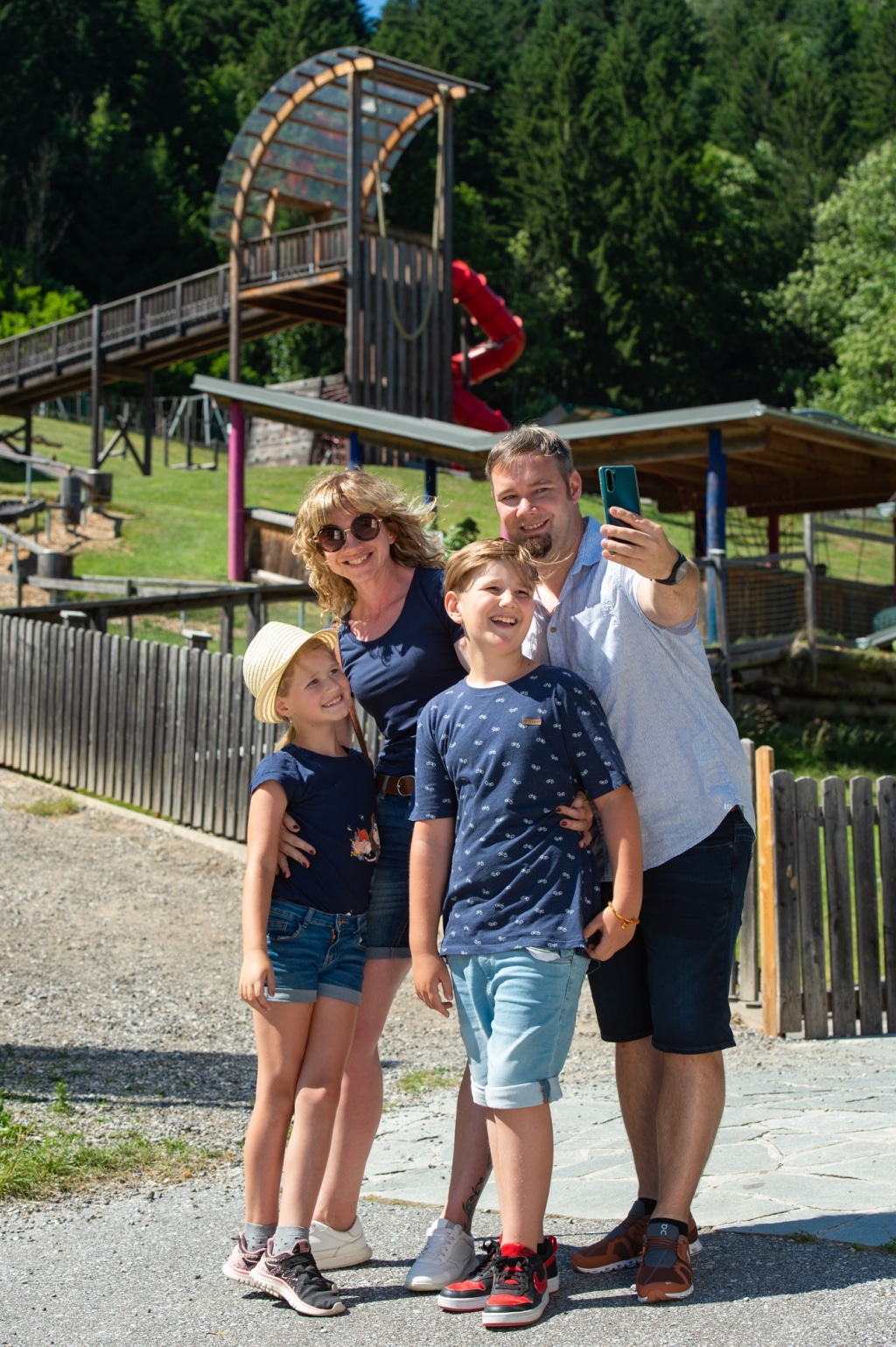 Eine Familie macht ein Selfie vor dem Eingang zur Sommerrodelbahn in Koglhof