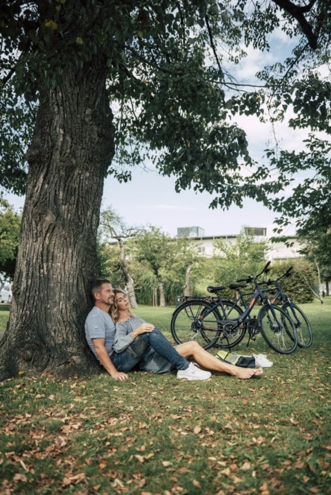 Zwei Personen unter einem Baum bei einer Radpause