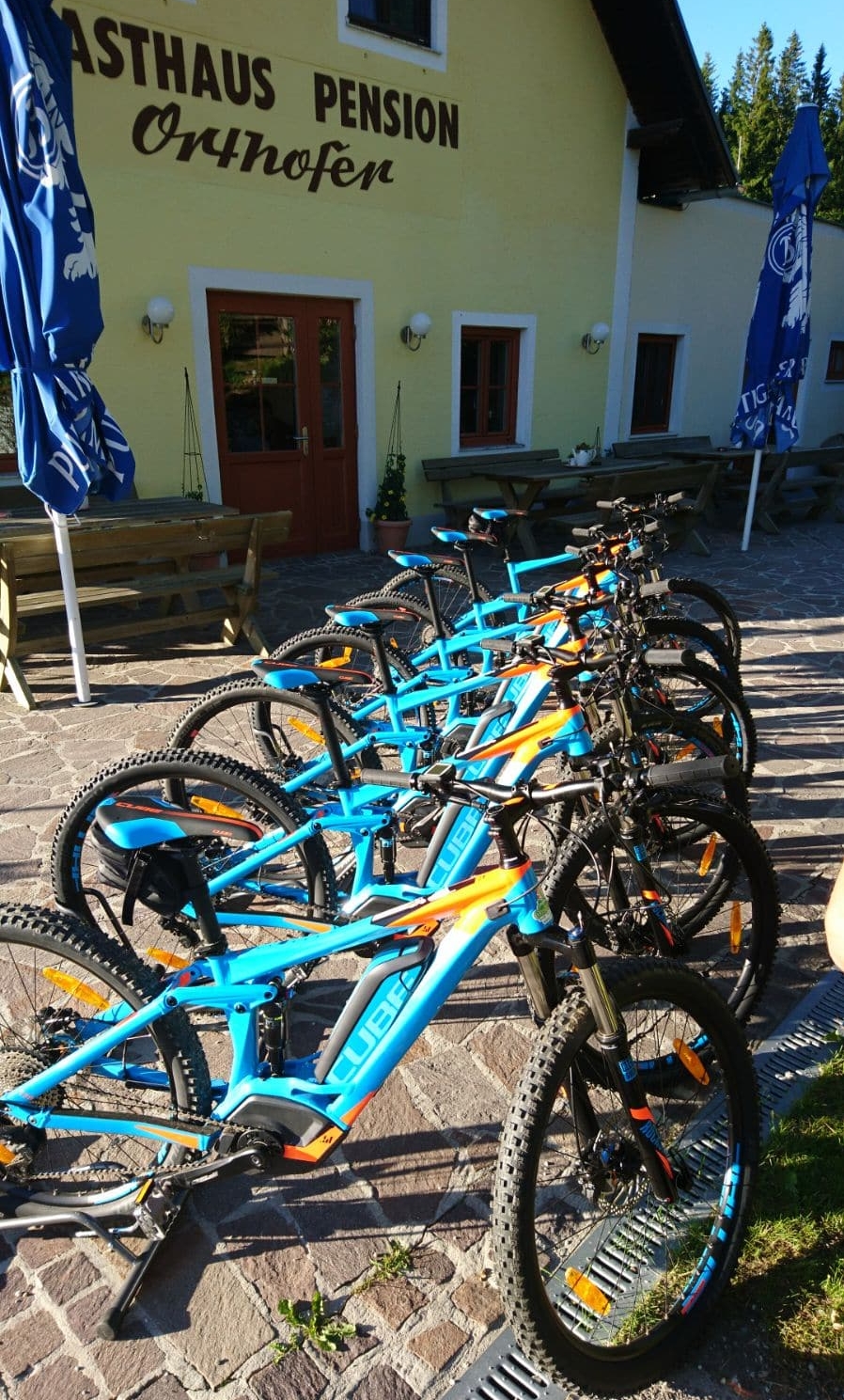 blaue E-MTBs vor dem Bikeverleih Orthofer