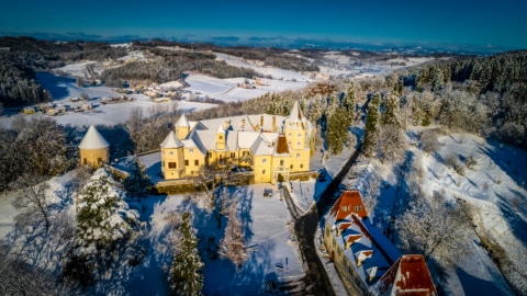 in Schnee gedeckte Landschaft mit einem gelben Schloss von Oben fotografiert